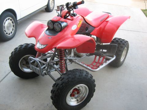 1995 Ford Bronco - This red ATV has a unique, grinning face decal on its front. The album claims it's a 1995 Ford Bronco.