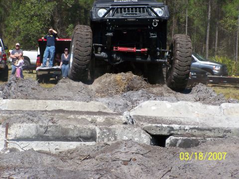 1989 Ford Bronco - Off-road vehicle navigates a challenging obstacle course with spectators watching.