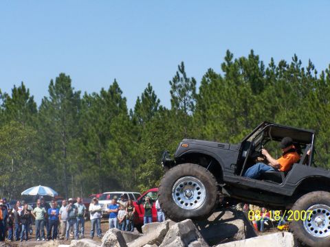 1989 Ford Bronco - Off-road vehicle navigates a rocky obstacle course with spectators watching.