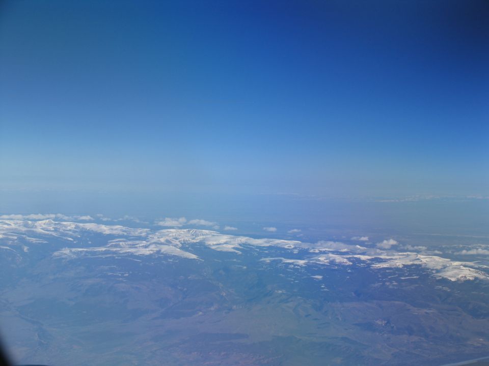 Aerial view of snow-capped mountains under a clear blue sky