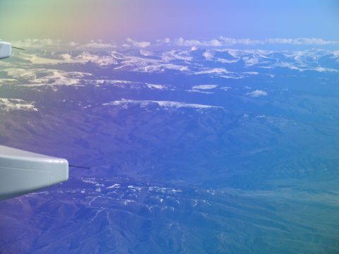 1995 Ford C-350 (Centurion Conversions) - View from an airplane window shows a vast expanse of mountains and valleys under a gradient sky.