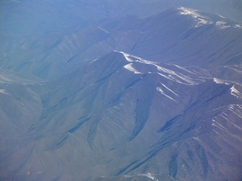 1995 Ford C-350 (Centurion Conversions) - An aerial perspective captures the vastness of mountain ranges, with patches of snow highlighting their peaks.