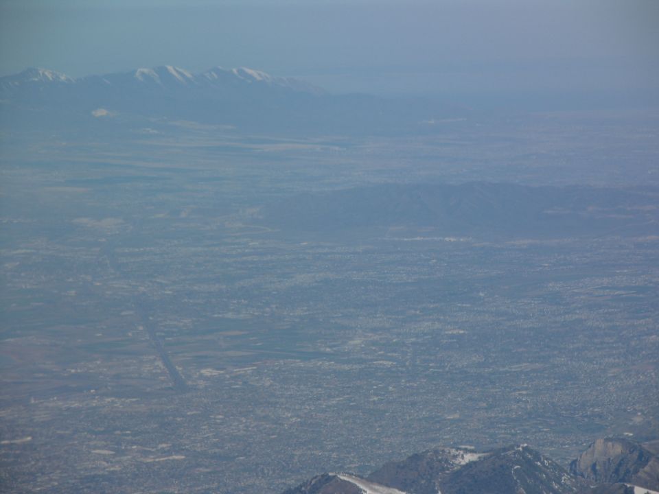 Aerial shot looking down on a city in a valley, with mountains in the distance