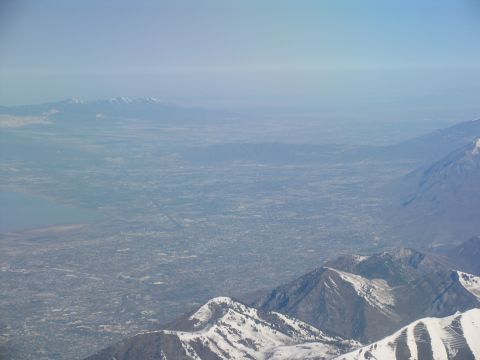 1995 Ford C-350 (Centurion Conversions) - An aerial view captures a vast valley dotted with buildings, bordered by mountains and a distant lake.