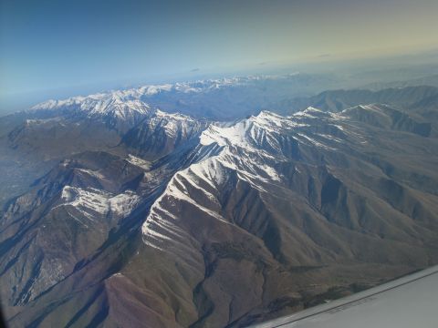 1995 Ford C-350 (Centurion Conversions) - Aerial view of vast mountain ranges with snow on their peaks under a clear blue sky.