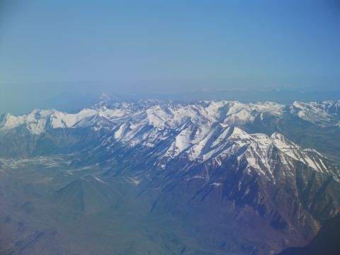 1995 Ford C-350 (Centurion Conversions) - Expansive mountain landscape seen from above, with snow-covered summits under a clear sky.