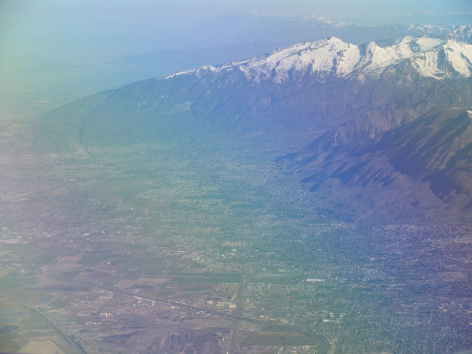 Aerial view of a valley with snow-capped mountains in the background