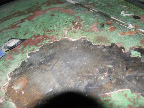 1995 Ford C-350 (Centurion Conversions) - Close-up of a heavily weathered metal surface with chipped paint and visible rust, showing signs of wear and tear.