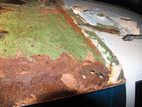 1995 Ford C-350 (Centurion Conversions) - The metal shows significant rust and damage, with layers of paint flaking off.