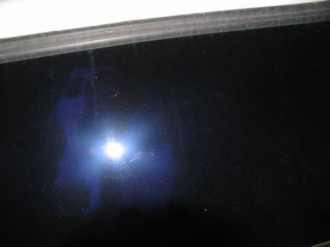 1995 Ford C-350 (Centurion Conversions) - Close-up of a dark blue vehicle panel, showing reflections and surface imperfections.