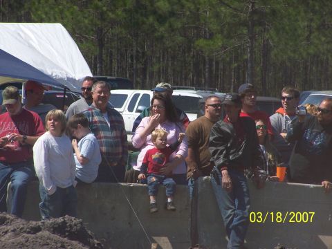 1989 Ford Bronco - People gather to watch an event, with several vehicles visible in the background.
