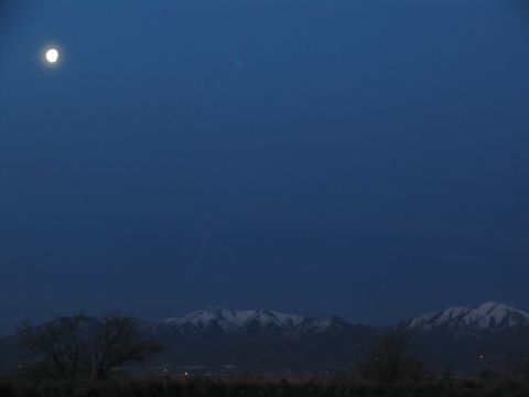 1995 Ford C-350 (Centurion Conversions) - A full moon hangs in the twilight sky above snow-dusted mountains.