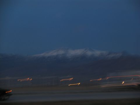 1995 Ford C-350 (Centurion Conversions) - Streaks of light blur across the foreground of a dark, mountainous landscape at twilight.