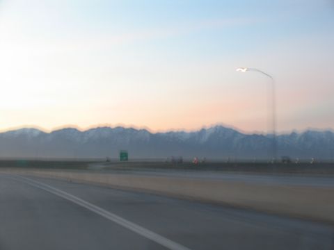 1995 Ford C-350 (Centurion Conversions) - Driving on a highway with a mountain range visible at sunset.