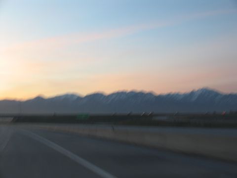 1995 Ford C-350 (Centurion Conversions) - Driving on a highway with a mountain range visible at sunset.