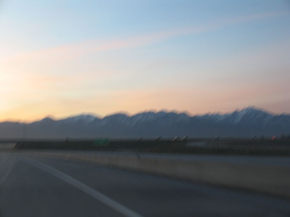 Highway lane with mountains in the distance during sunset