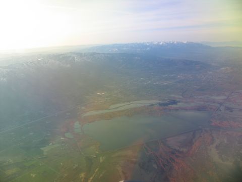 1995 Ford C-350 (Centurion Conversions) - Expansive aerial view showing mountains, a lake, and surrounding terrain under a bright sky.