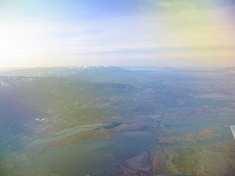 1995 Ford C-350 (Centurion Conversions) - An aerial view shows a valley with mountains, a lake, and scattered development under a hazy sky.