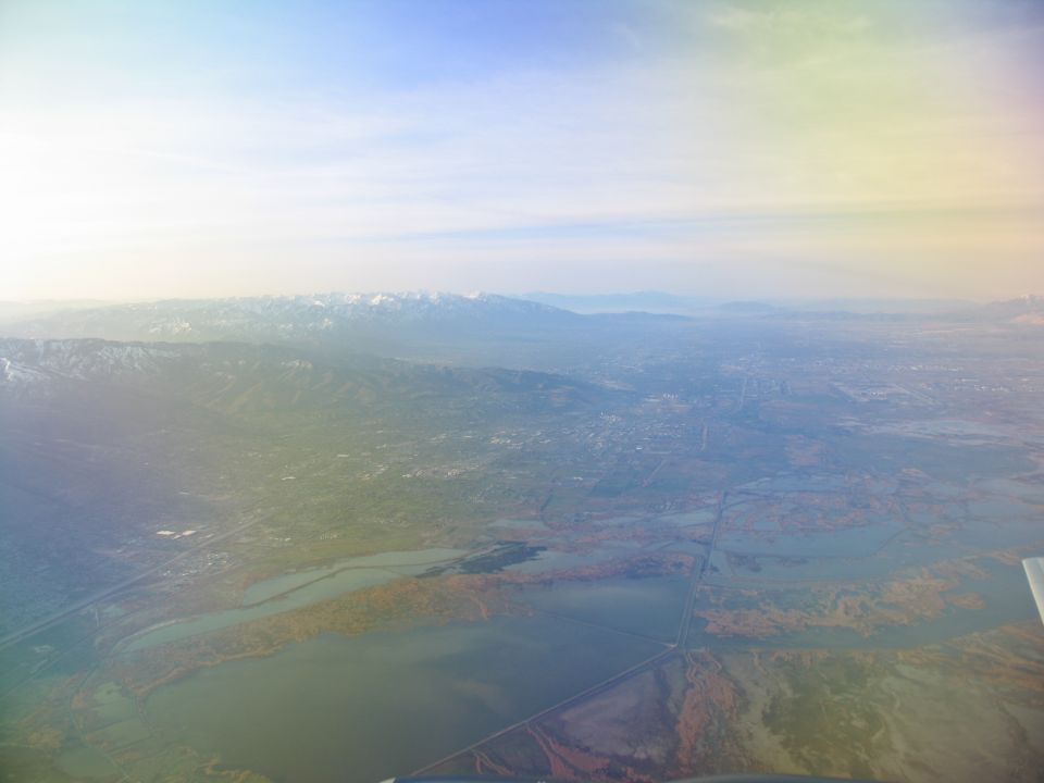 Aerial view of a valley with mountains in the distance and a body of water