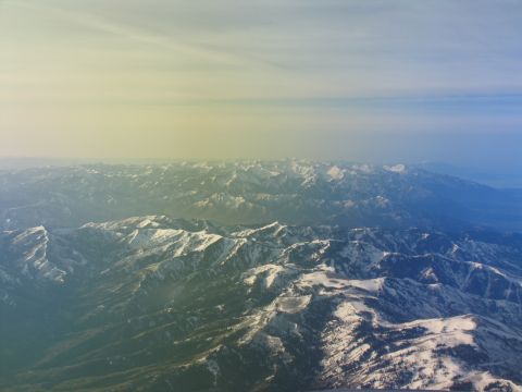 1995 Ford C-350 (Centurion Conversions) - Expansive mountain landscape seen from above, with snow dusting the peaks and valleys.
