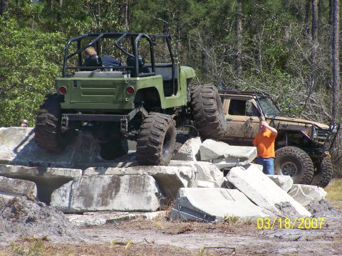 1989 Ford Bronco - Off-road vehicles navigate a challenging course of concrete obstacles during an event.