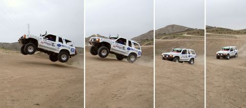 1992 Ford Explorer - Multiple white Ford Explorers navigate a dusty off-road course, with one vehicle captured mid-air.