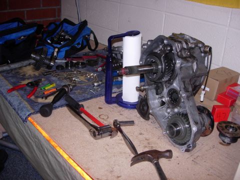 1985 Toyota Hilux - Tools and a disassembled vehicle transmission or transfer case are laid out on a workbench.