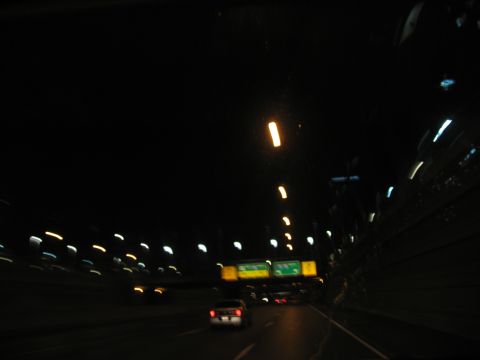 1995 Ford C-350 (Centurion Conversions) - Driving on a highway at night, with blurred lights creating streaks of color across the dark scene.