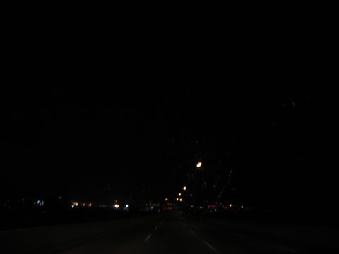 1995 Ford C-350 (Centurion Conversions) - View from a vehicle traveling on a highway at night, with lights visible in the distance.