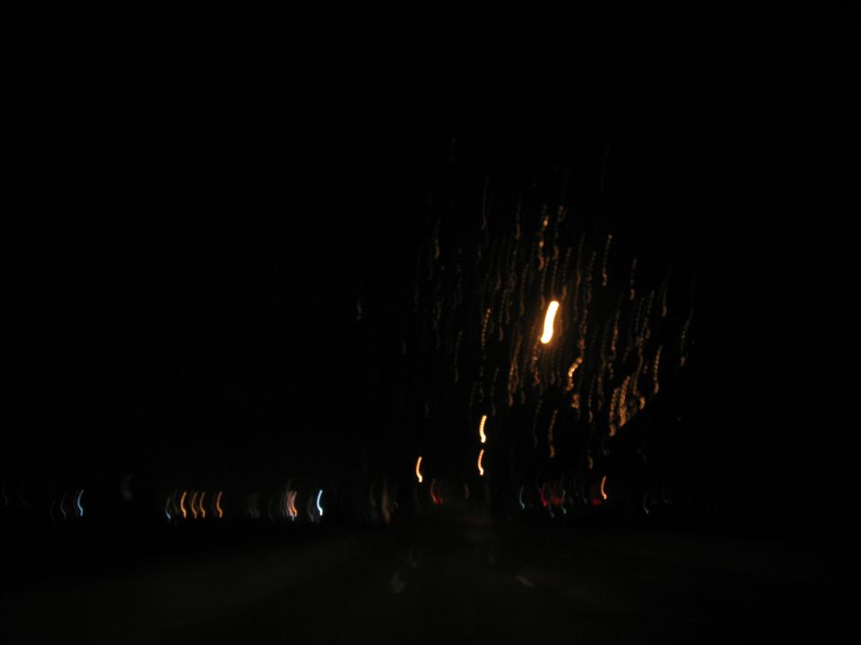 Blurry streaks of light at night, possibly from moving vehicles or fireworks