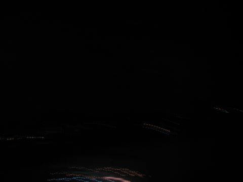1995 Ford C-350 (Centurion Conversions) - Abstract streaks of light blur across a dark background, suggesting motion at night.