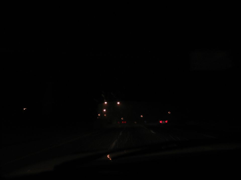 Dark road at night with distant lights