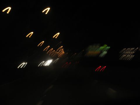 1995 Ford C-350 (Centurion Conversions) - Blurry lights streak across the dark frame, suggesting motion on a road at night.