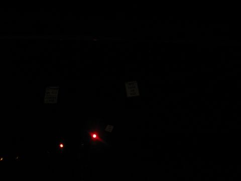 1995 Ford C-350 (Centurion Conversions) - A dark scene shows two signs and two red lights, possibly traffic signals.