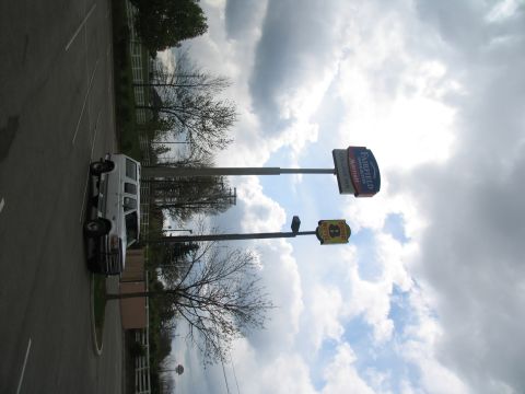 1995 Ford C-350 (Centurion Conversions) - A white van is parked in a lot under a cloudy sky.