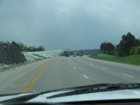 1995 Ford C-350 (Centurion Conversions) - View from a car driving on a highway with other vehicles under a cloudy sky.