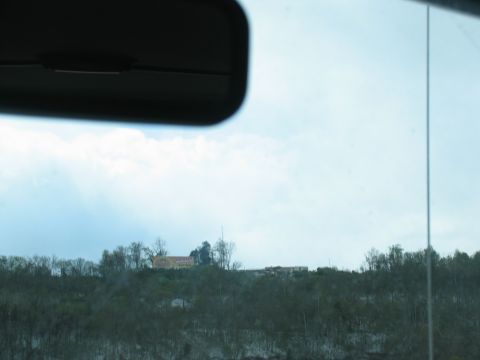 1995 Ford C-350 (Centurion Conversions) - View from inside a vehicle looking out at a distant landscape with buildings and trees.