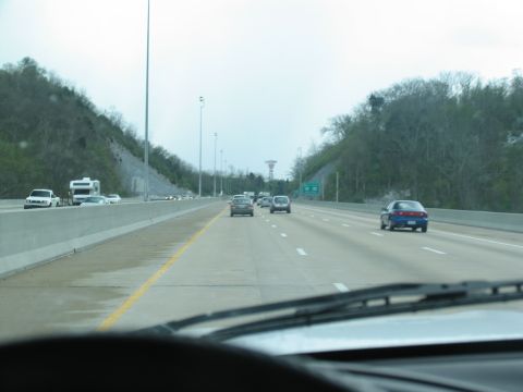 1995 Ford C-350 (Centurion Conversions) - A view from the driver's seat shows a highway with several cars and an RV traveling in the same direction.