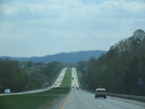 1995 Ford C-350 (Centurion Conversions) - A highway stretches into the distance with vehicles traveling in both directions under a cloudy sky.