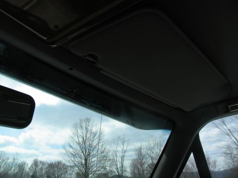 1995 Ford C-350 (Centurion Conversions) - Interior shot showing the vehicle's headliner, visor, and a glimpse of the sky and trees through the windshield.