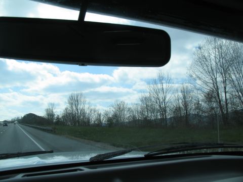 1995 Ford C-350 (Centurion Conversions) - Driving down the highway with a view of trees and clouds.