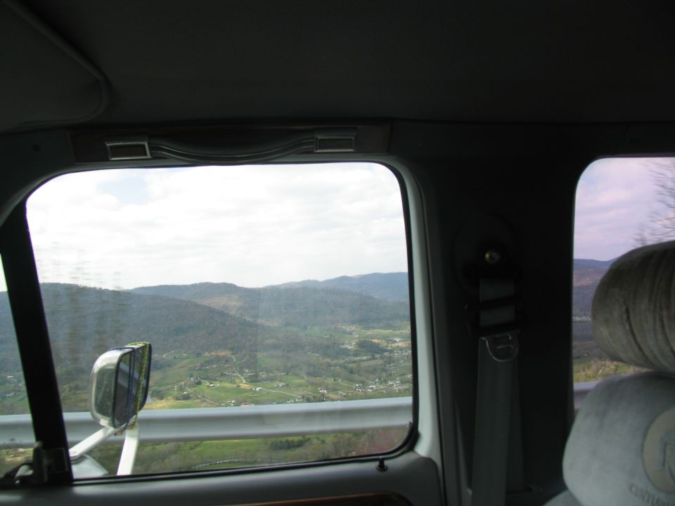 View from inside a vehicle showing a landscape with hills and scattered houses