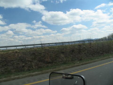 1995 Ford C-350 (Centurion Conversions) - A car is visible in the side mirror of the vehicle capturing this image.
