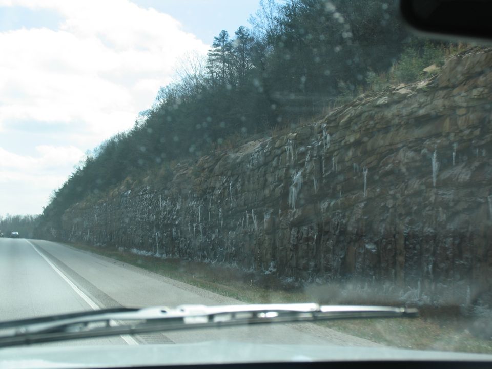 Roadside cliff with icicles, seen from a vehicle interior