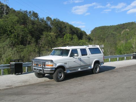 1995 Ford C-350 (Centurion Conversions) - White 1995 Ford C-350 (Centurion Conversions) pickup truck with camper shell parked roadside.