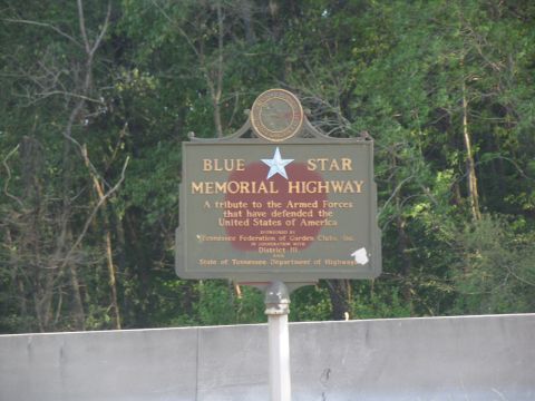 1995 Ford C-350 (Centurion Conversions) - A sign for the Blue Star Memorial Highway is visible against a backdrop of trees.