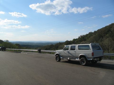 1995 Ford C-350 (Centurion Conversions) - A white 1995 Ford C-350 (Centurion Conversions) is parked on the side of a road with a scenic overlook.