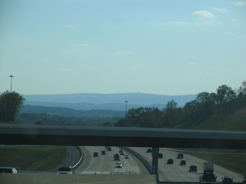 Highway traffic with distant mountains under a blue sky