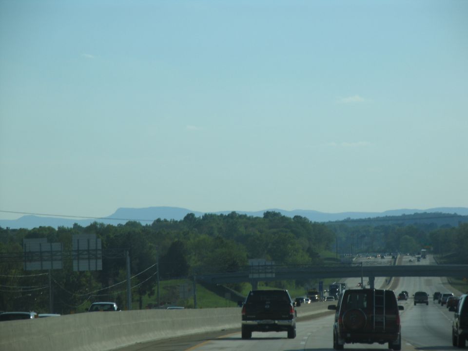 Highway scene with multiple vehicles driving on a sunny day