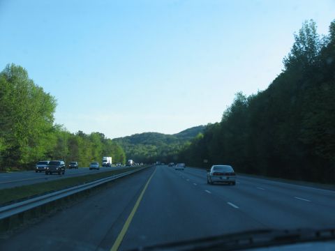 1995 Ford C-350 (Centurion Conversions) - Driving on a highway with trees and hills in the background.